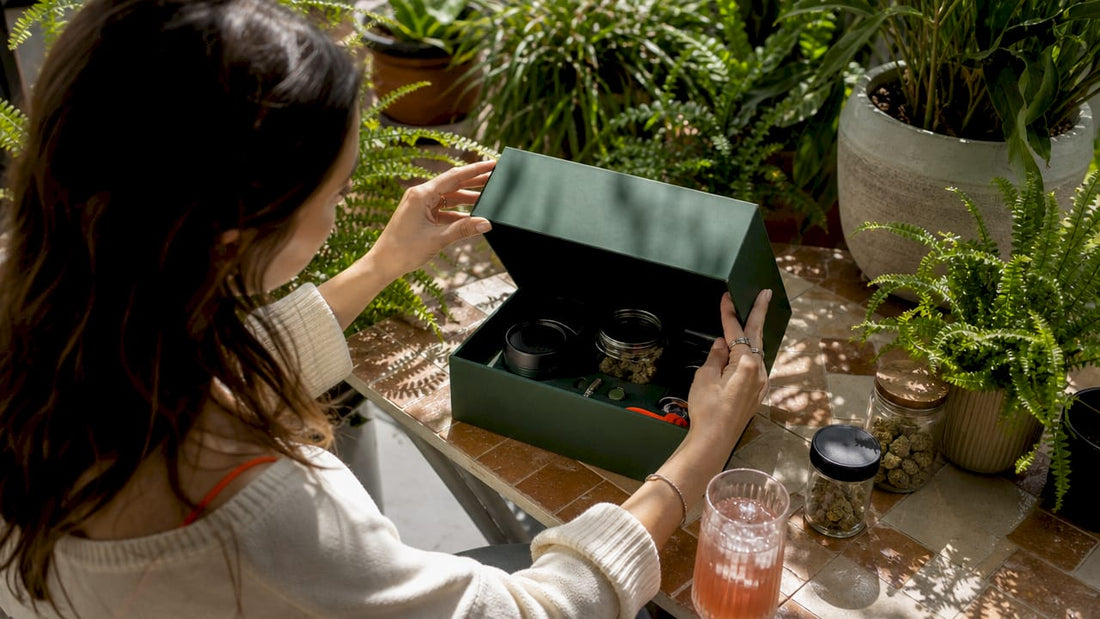 Person unboxing cannabis gift box at home table